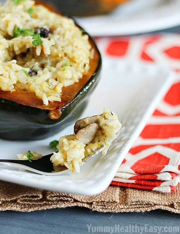 Stuffed Acorn Squash | Baked acorn squash are stuffed with a delicious rice and mushrooms mixture, topped with parmesan cheese and then baked again. Makes a great side dish or vegetarian main dish option! Stuffed Acorn Squash