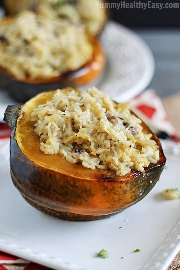 Stuffed Acorn Squash | Baked acorn squash are stuffed with a delicious rice and mushrooms mixture, topped with parmesan cheese and then baked again. Makes a great side dish or vegetarian main dish option! Stuffed Acorn Squash