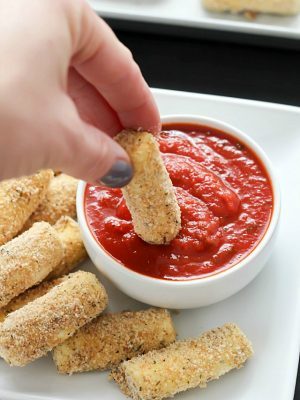 Quick and easy Baked Mozzarella Sticks for the win! A fast crowd-pleasing appetizer of warm and gooey cheese dipped in marinara sauce - yum!