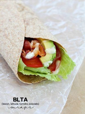 Bacon, Lettuce, Tomato & Avocado wrap on some parchment paper.