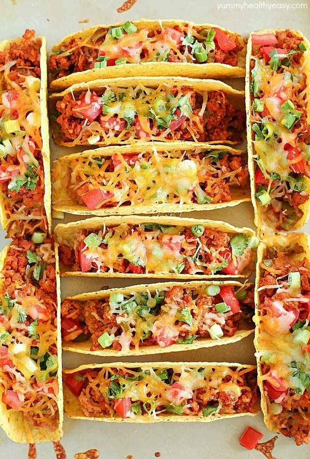 Ground Turkey Tacos that are oven-baked with layers of deliciousness inside! Refried beans, ground turkey taco meat, (no taco seasoning mix!) tomato, cilantro, green onions and cheese all baked in taco shells. Perfect for Taco Tuesday or for game day! AD
