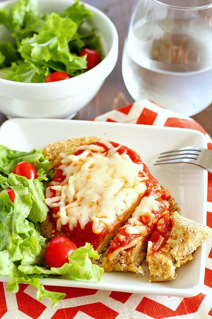 Time to change up that fattening Chicken Parmesan Recipe and make it skinny!! This lightened up comfort food dish is super easy to make and made healthier by baking instead of frying among other things. You need to add this Skinny Chicken Parmesan to your weekly dinner rotation!