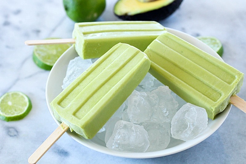 Creamy Avocado Coconut Popsicles - every bite is a tropical getaway! Who would have thought that avocado in a popsicle would be so delicious? You get a little coconut, lime and avocado in every bite of these popsicles! AD