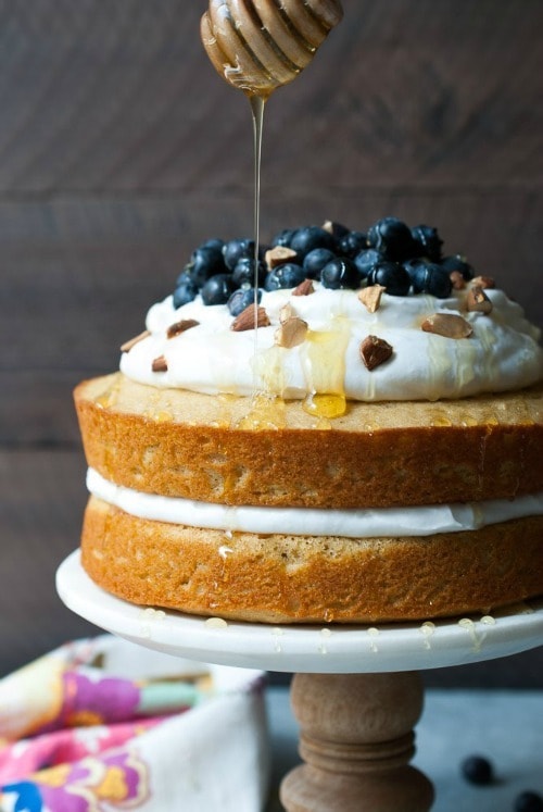 This Lemon Blueberry Olive Oil Cake uses white whole wheat flour, greek yogurt, olive oil, and it’s topped with an amazing coconut whipped cream, fresh berries, chopped almonds, and a drizzle of honey. What’s not to love?