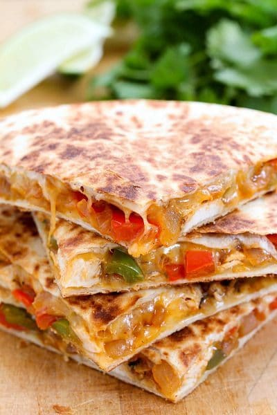 The Best Ever Cheesy Chicken Fajita Quesadilla on a cutting board.