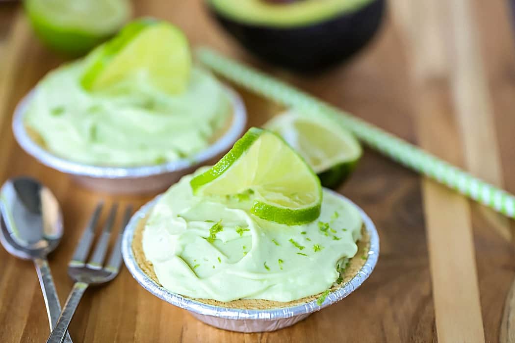 Horizontal photo of two mini key lime pies topped with sliced limes