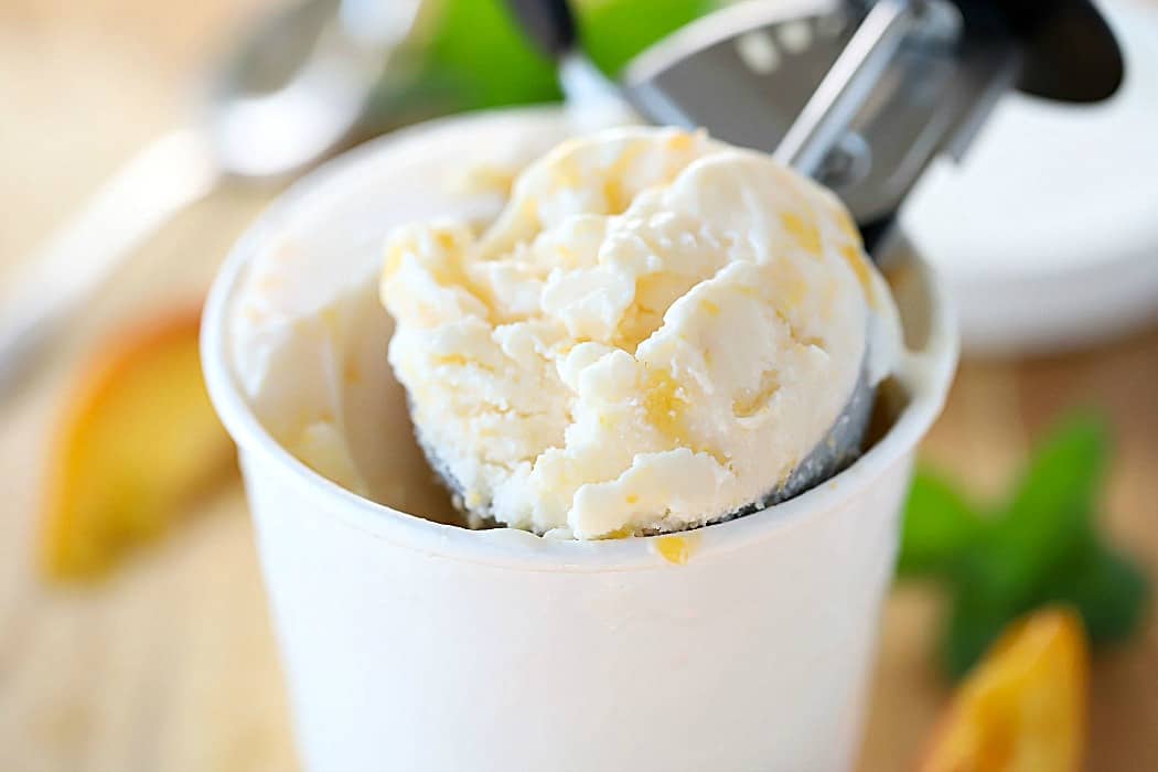 Horizontal photo of a large scoop of frozen yogurt from a white carton.