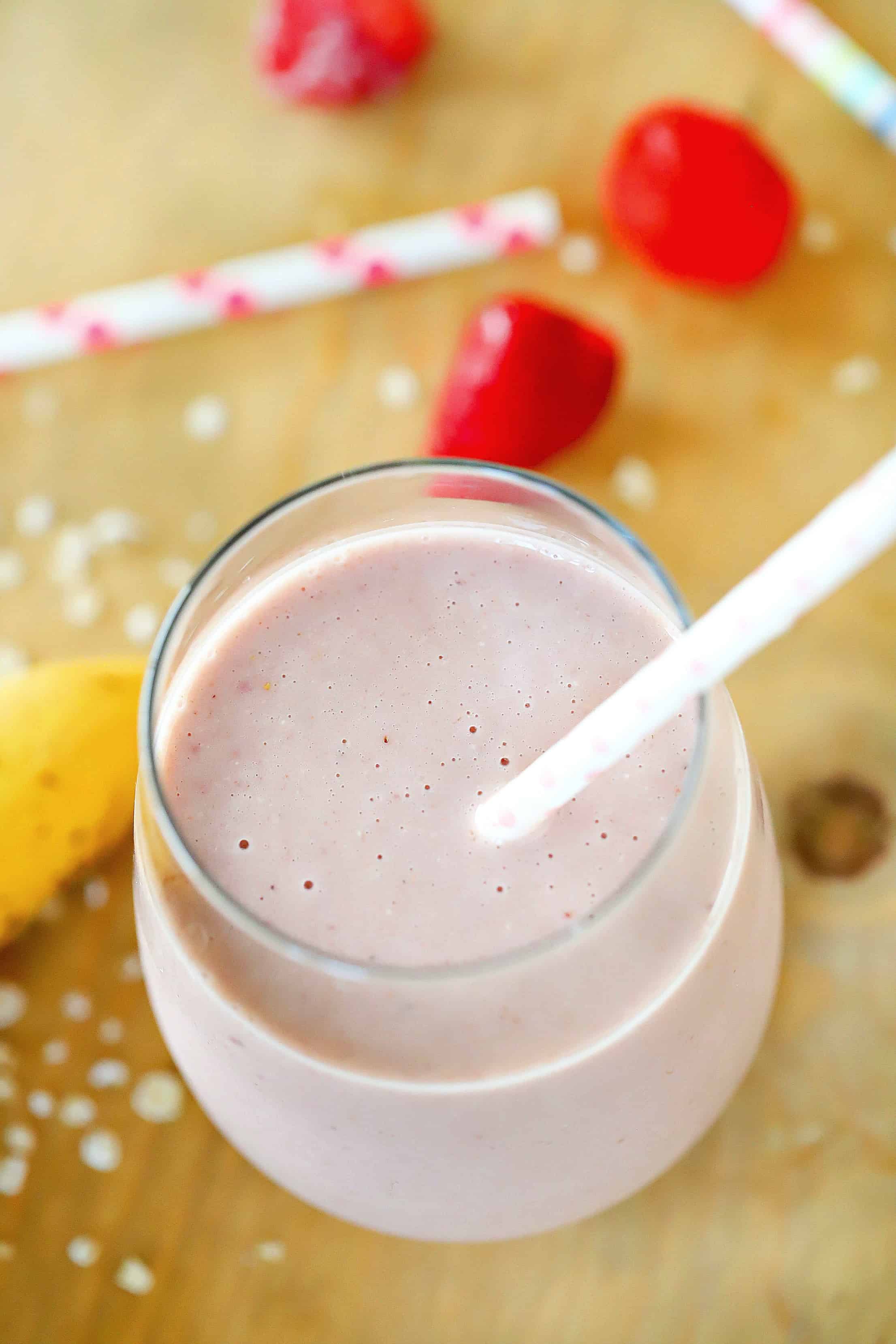 Overhead view of a smoothie with a background of bananas and strawberries, straws and oats. :)