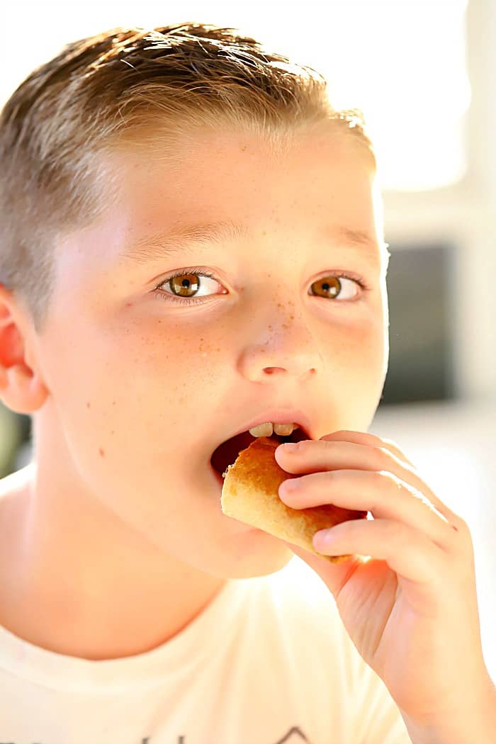 A cute boy eating a beef empanada