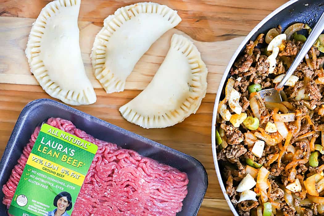 Overhead picture of Laura's Lean Ground Beef with empanada filling and three uncooked empanadas