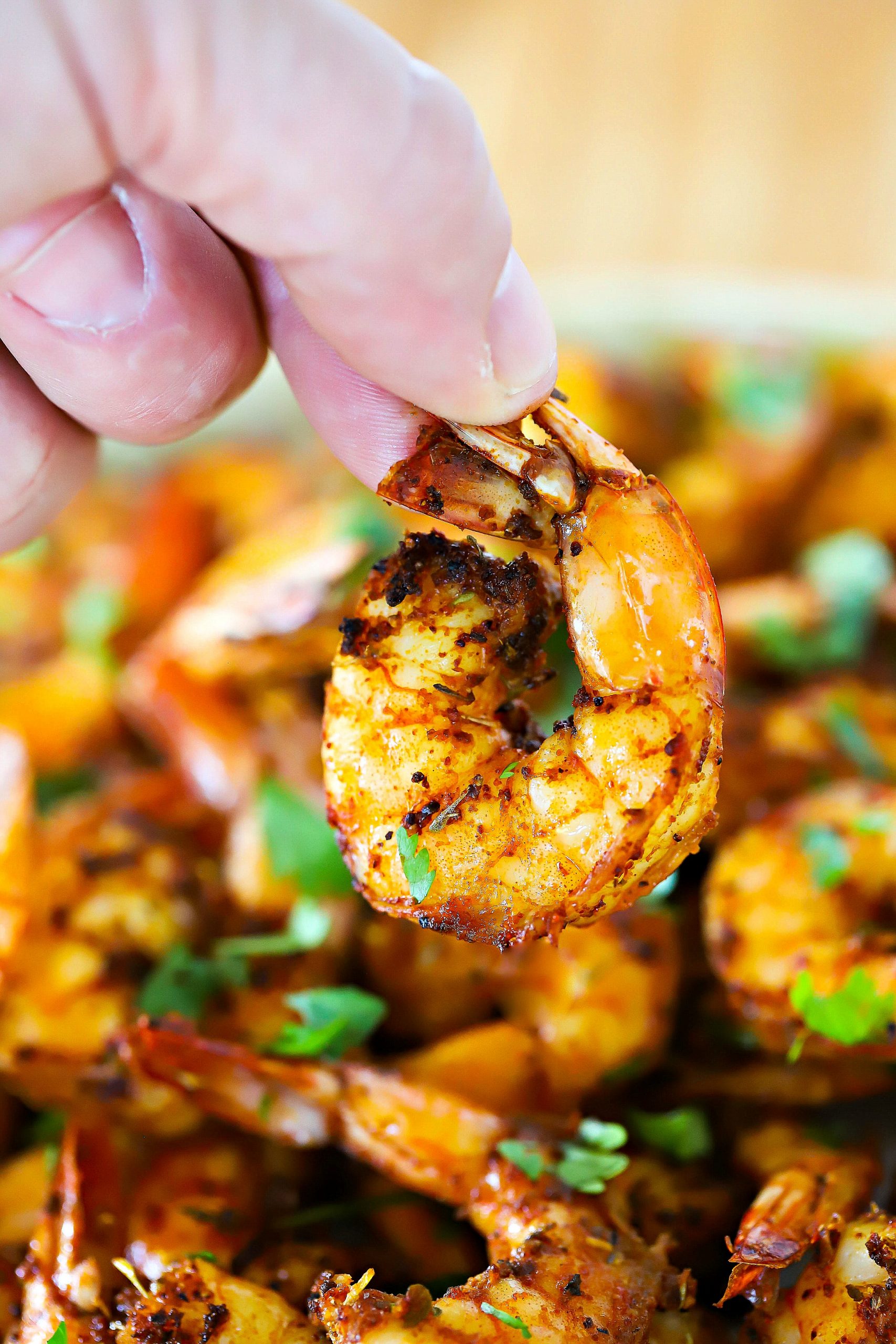One shrimp being held up by a hand.