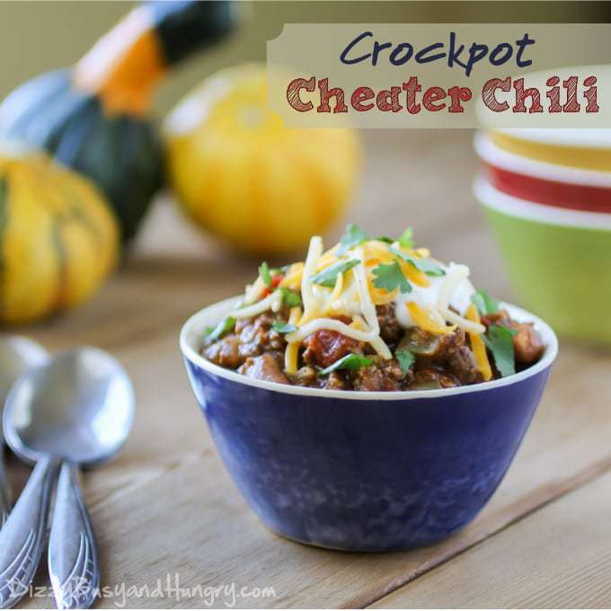 Blue bowl filled with chili and topped with cheese and cilantro.