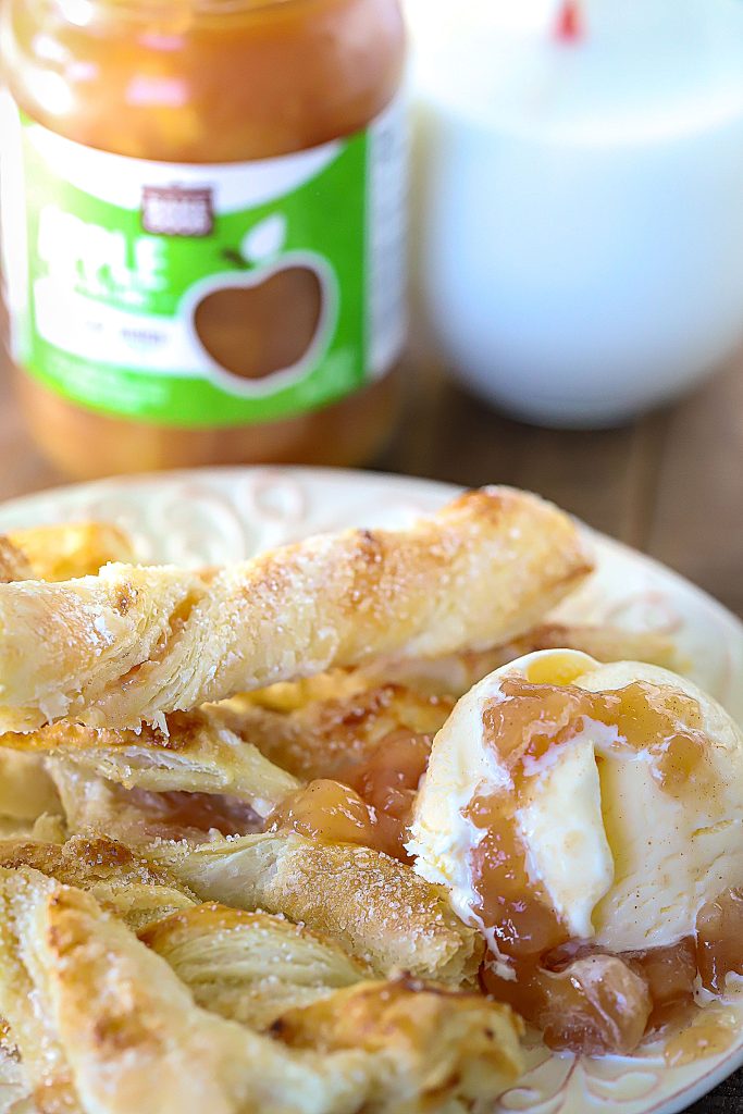A plate full of strudel twists with a side of vanilla ice cream topped with apple pie filling.