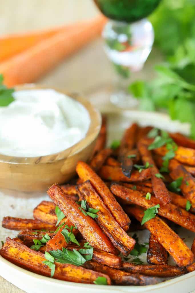 Carrot slices on a plate with a dip on the side.