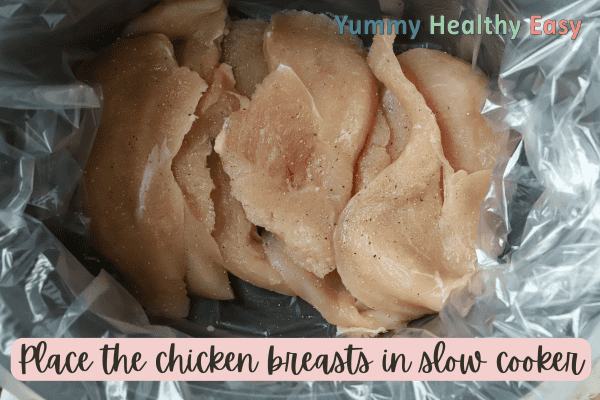 Crock Pot filled with boneless skinless chicken breasts.