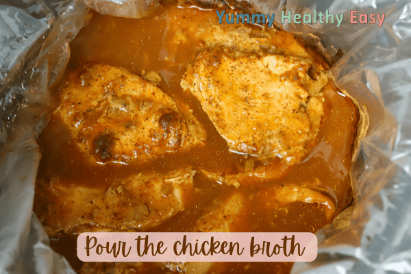 Crock Pot filled with boneless skinless chicken breasts, topped with low sodium taco seasoning and broth.